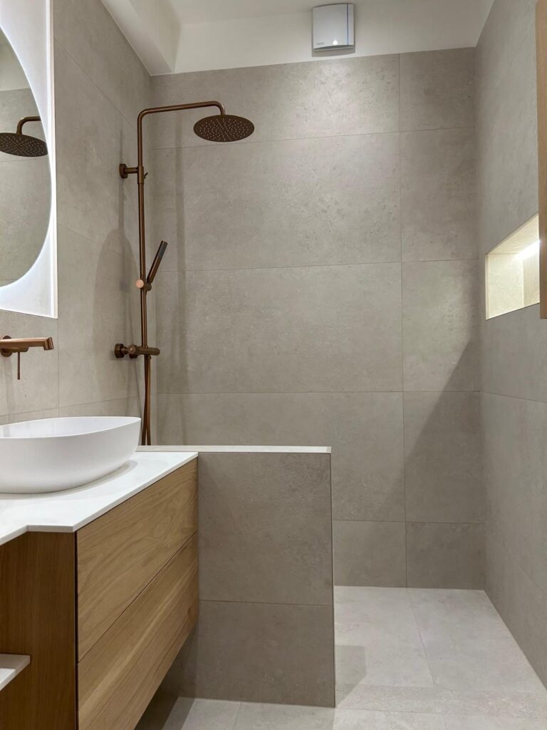 Douche à l'italienne avec robinetterie cuivre et niche éclairée – salle de bain rénovée à Bruxelles